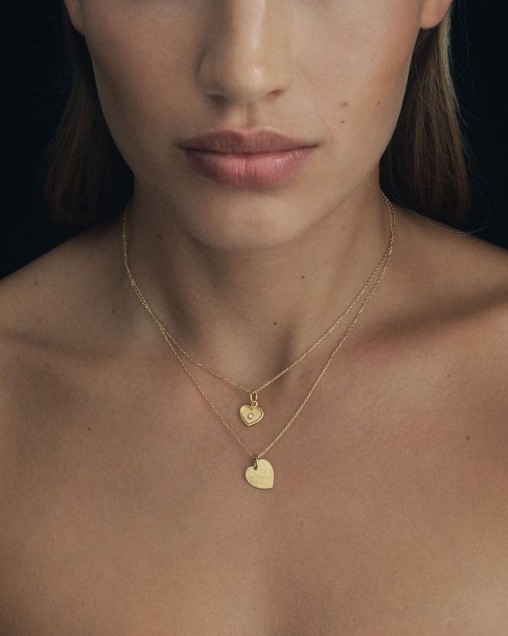 Graced with eagle reliefs on both sides, this solid gold heart necklace embodies bravery and love. The design draws inspiration from the Latin word for heart, originally signifying the courageous expression of one's true feelings.  
 Crafted from 24k solid gold, this double-sided pendant exudes a rich, tactile lustre that enhances its allure. A 14k yellow gold curb chain completes the Courage Necklace. Gold Plated Heart Pendant Necklace Tarnish Resistant, Gold Necklace With Heart Charm And Round Pendant, Yellow Gold Plated Heart Pendant Necklace, Gold Plated Yellow Gold Heart Pendant Necklace, Yellow Gold Heart Pendant Jewelry With Engraving, Yellow Gold Engraved Heart Pendant Jewelry, Yellow Gold Heart Charm Necklace With Round Pendant, Yellow Gold Sterling Silver Heart Pendant Necklace, Yellow Gold Round Pendant Heart Necklace, Tarnish Resistant