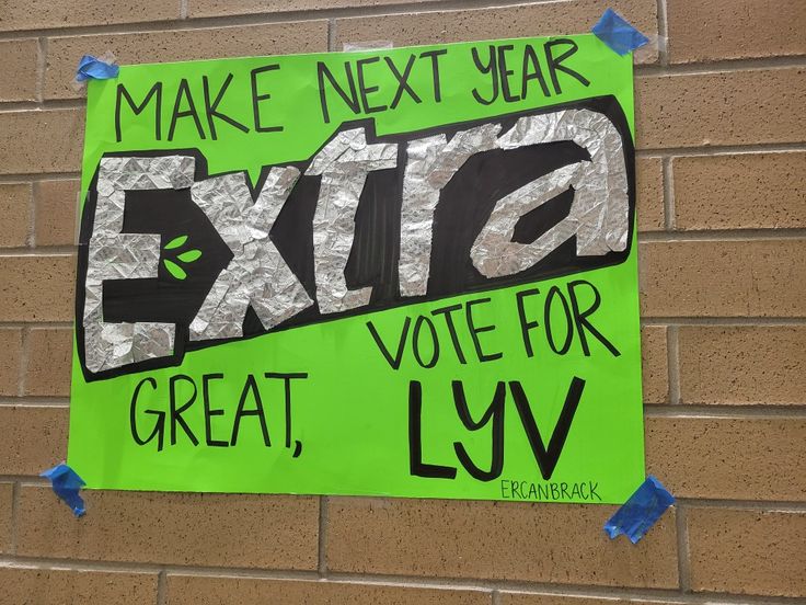 a green sign that says make next year extra great, for lyv on the side of a building