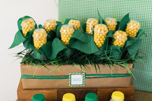 there is a box with corn on the cob in it and some bottles next to it