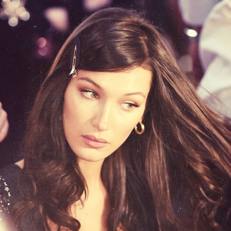 a close up of a person with long hair and wearing earring on her head