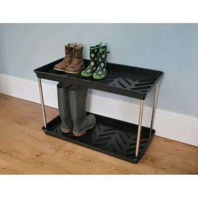 a pair of boots sitting on top of a black shelf next to a wooden floor