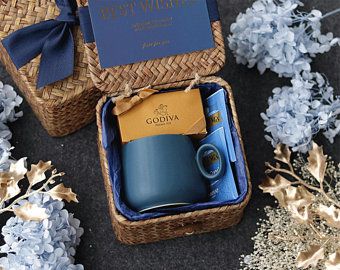 two blue coffee mugs in a wicker box with the words best wishes written on them