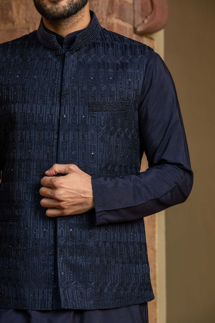 Editor's Note Featuring A Navy Blue Viscose Silk Kurta And Churidar With Raw Silk Jacket All Over Embroidered In Resham, Crystal And Beadwork Color: Navy Blue Fabric: Bundi: Raw Silk, Kurta And Churidar: Viscose Silk Component: Bundi, Kurta And Churidar Embroidery Details: Resham, Crystal And Beadwork Care: Dry Clean Only About the Designer Nitika Gujral’s journey with designing clothes started almost four decades back while she was still in high school and held her first exhibition for family a Churidar Embroidery, Raw Silk Kurta, Raw Silk Embroidery, Kurta Set For Men, Beads Embroidery, Silk Kurta, Navy Blue Fabric, Nehru Jackets, Pattern Embroidery