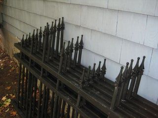 a row of black iron railings on the side of a house