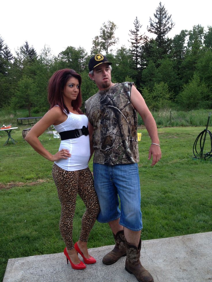 a man standing next to a woman on top of a cement slab in the grass