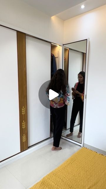 two women standing in front of an open door and looking at their reflection in the mirror