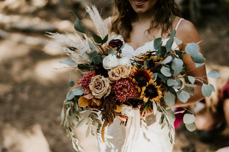 a woman holding a bouquet of flowers in her hands