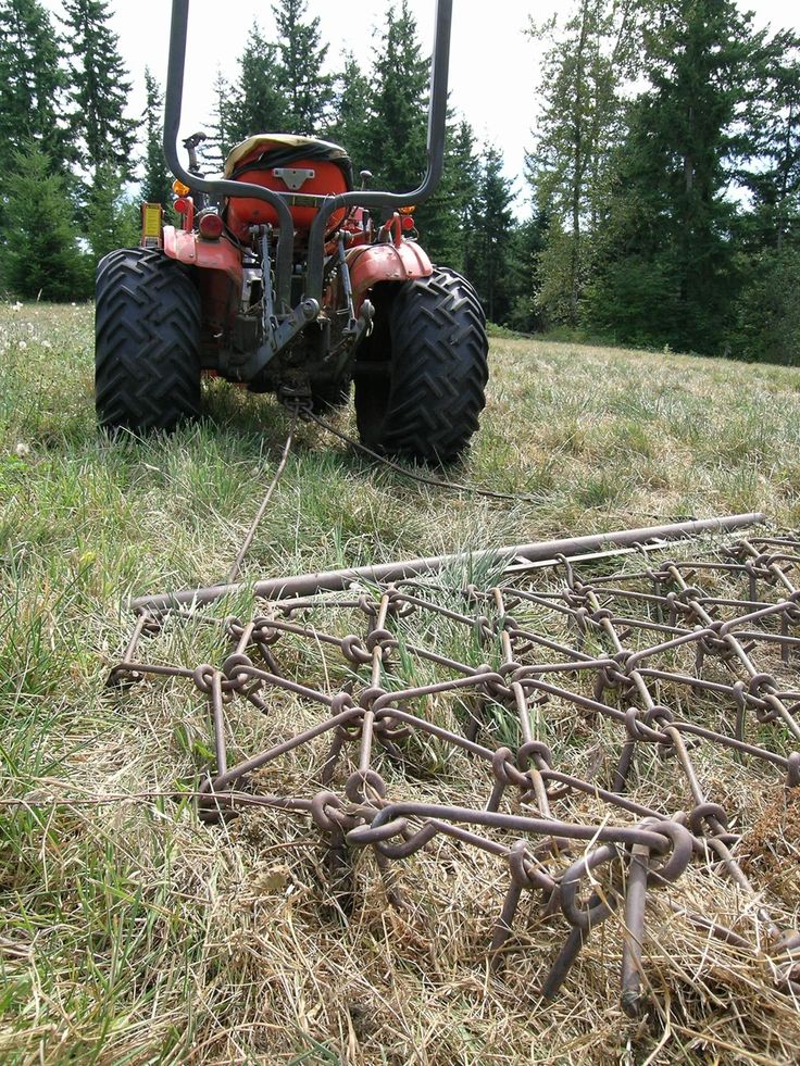 a tractor is parked in the middle of a field with many metal bars attached to it