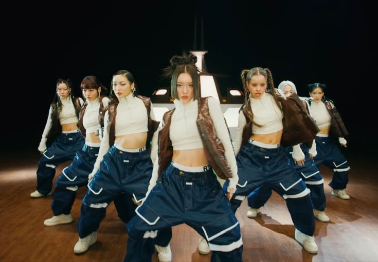 a group of young women standing on top of a wooden floor next to each other