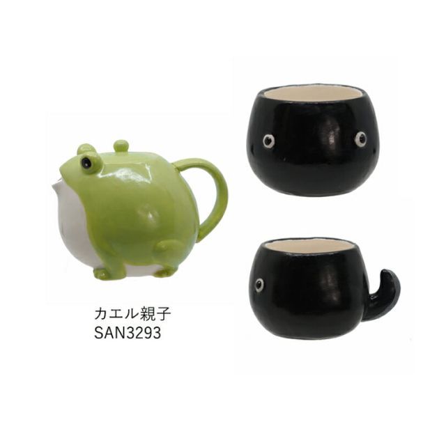 two black and one green ceramic mugs with faces on the sides, both shaped like a frog