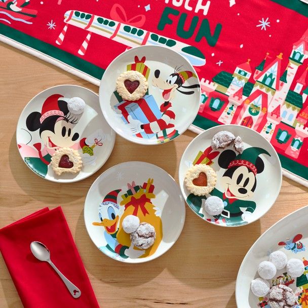 four plates with mickey mouse desserts on them next to a red napkin and place mat