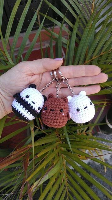 three crocheted keychains in the shape of panda, penguin and dog