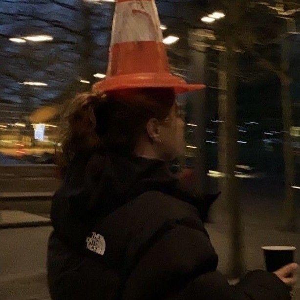 a woman wearing a red and white traffic cone hat