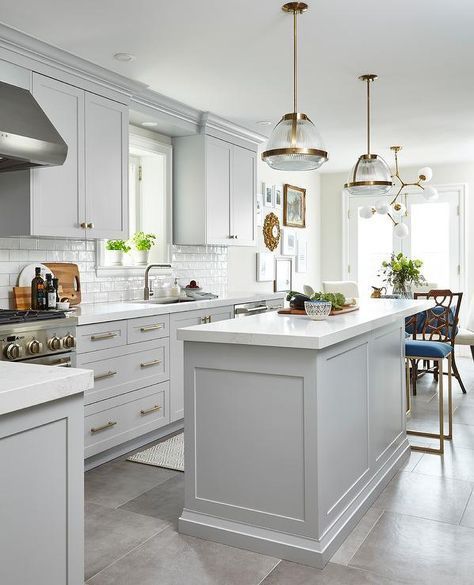 a large kitchen with white cabinets and an island