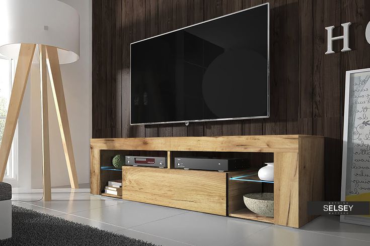 a flat screen tv sitting on top of a wooden entertainment center in a living room