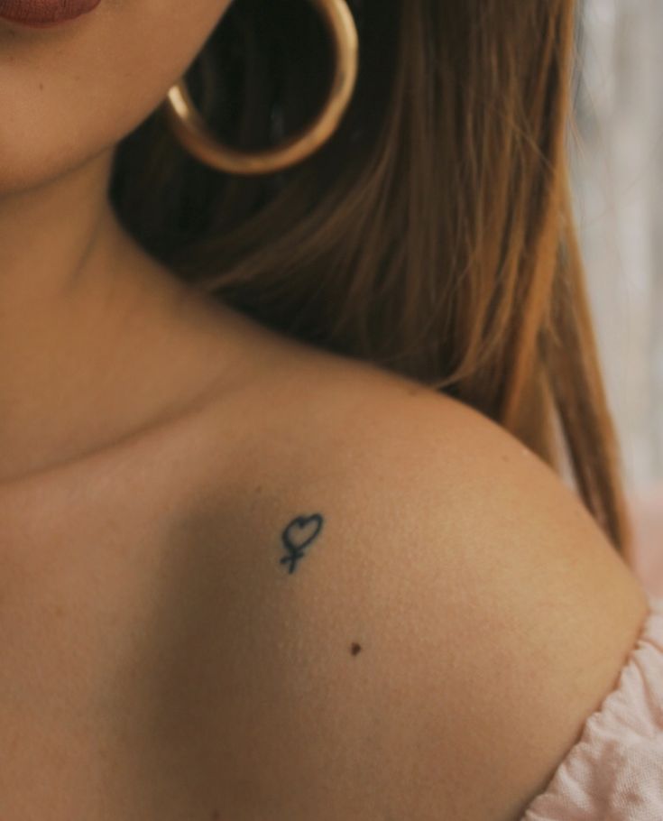 a woman with a small tattoo on her shoulder