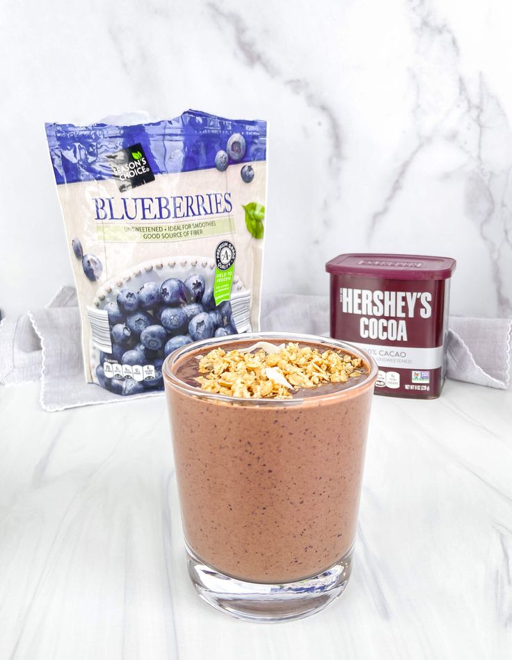 blueberries and granola in a glass bowl with yogurt next to it