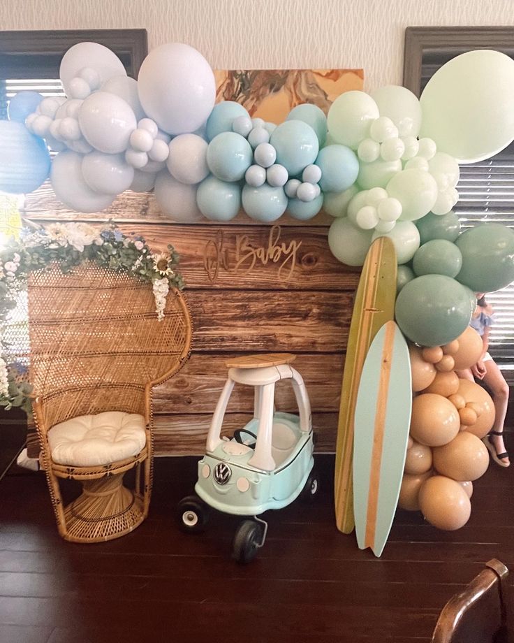 there is a surfboard and balloons on the wall next to a baby's stroller