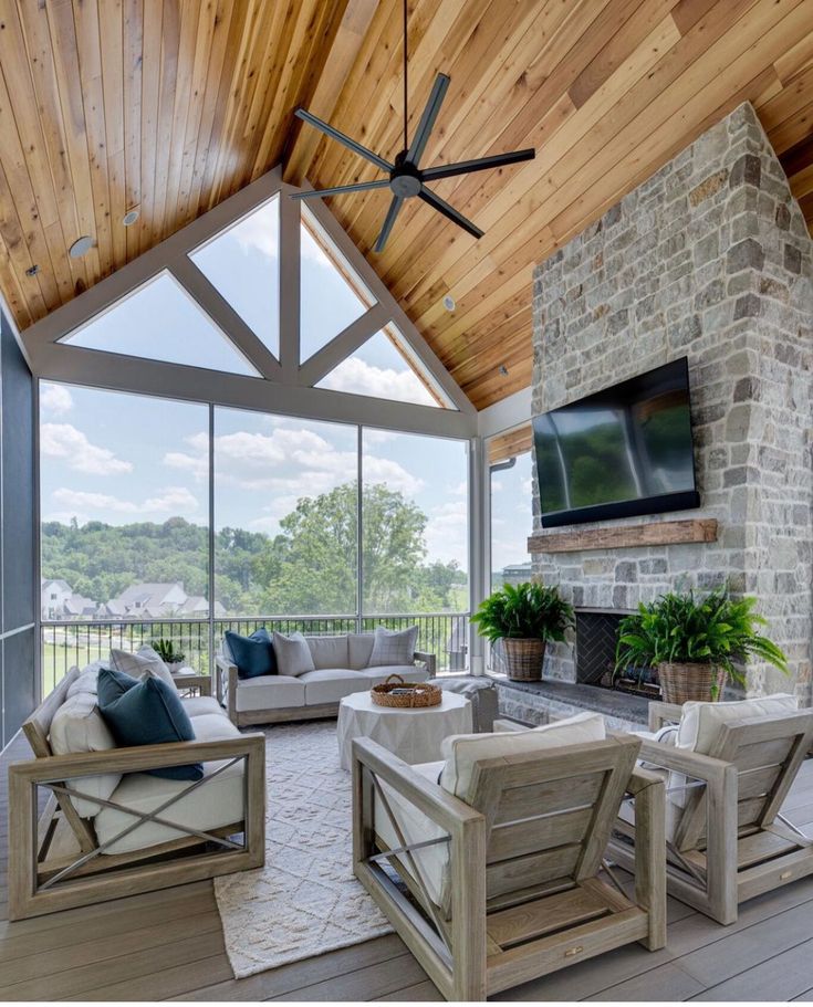 a living room filled with furniture and a flat screen tv mounted on the wall above a fireplace