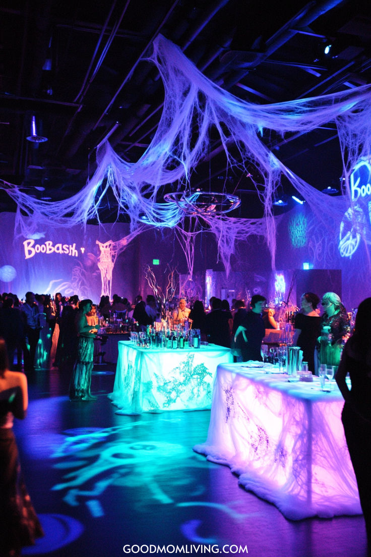 A vibrant party scene featuring colorful lighting and spooky decorations, including spider webs, with guests socializing around illuminated tables. Halloween Birthday Decoration Ideas, 60th Birthday Halloween Theme, Spooky Halloween Birthday Party, Prom Night Halloween Party, Huge Halloween Party, 16th Halloween Birthday Party, Middle School Halloween Dance Decorations, Halloween Dance Party Decorations, Spooky Party Decor