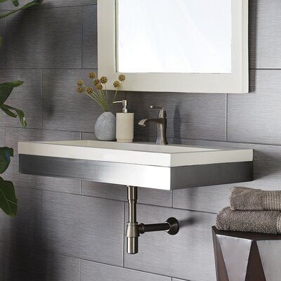 a bathroom sink sitting under a mirror next to a plant