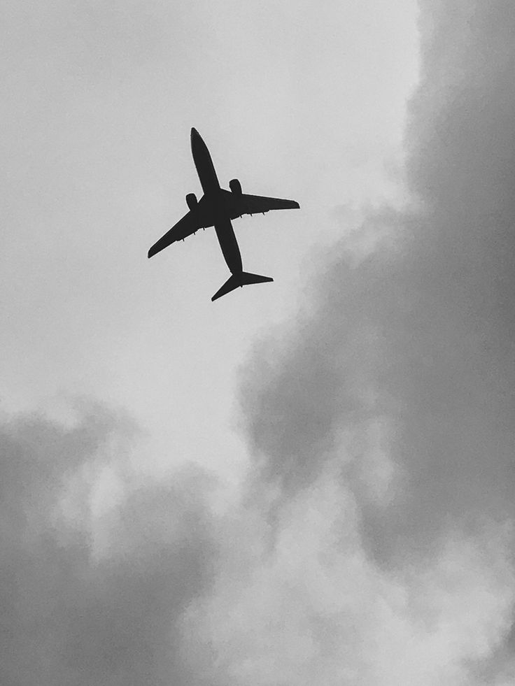 an airplane is flying through the cloudy sky