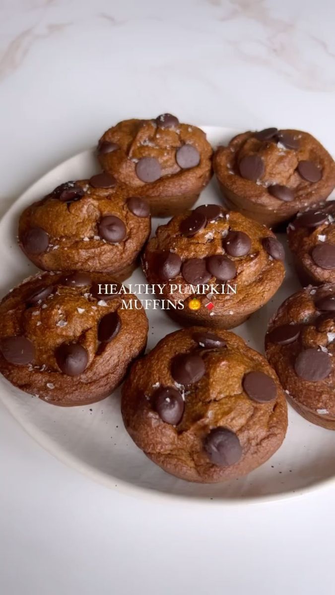 chocolate chip cookies on a white plate sitting on a marble counter top with the words healthy pumpkin muffins