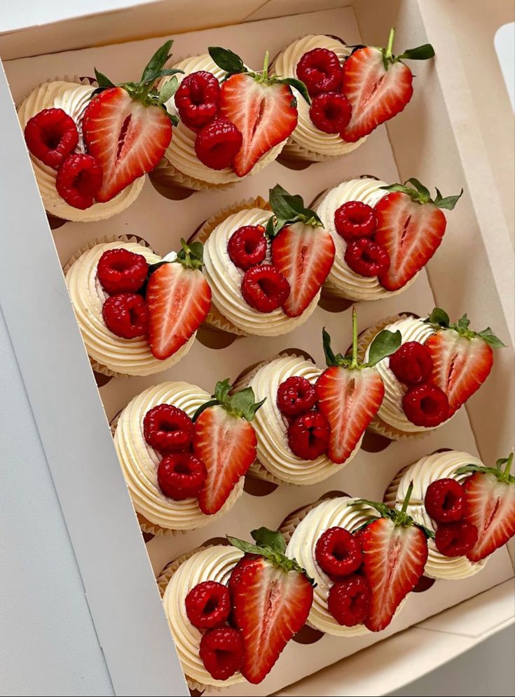 a box filled with cupcakes topped with strawberries