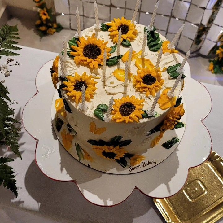 a cake with sunflowers and candles on it