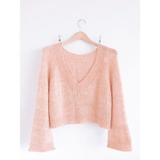 a pink sweater hanging on a hanger