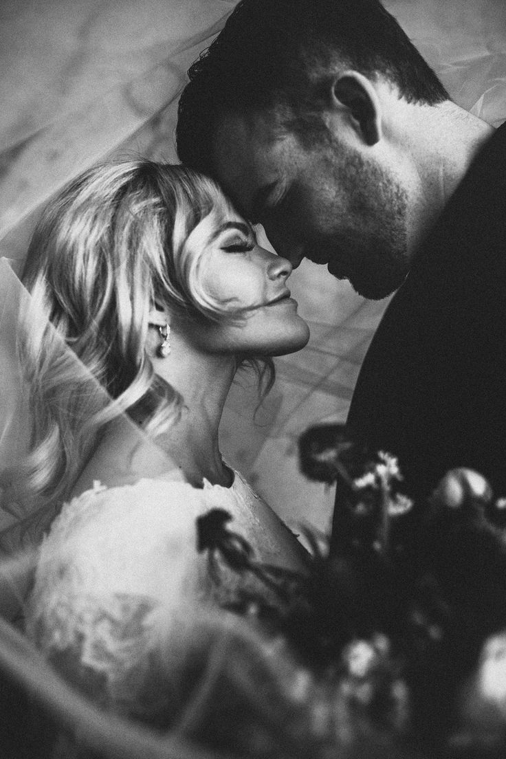 black and white photograph of a bride and groom kissing