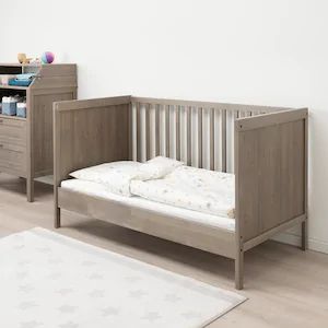 a baby crib and dresser in a room