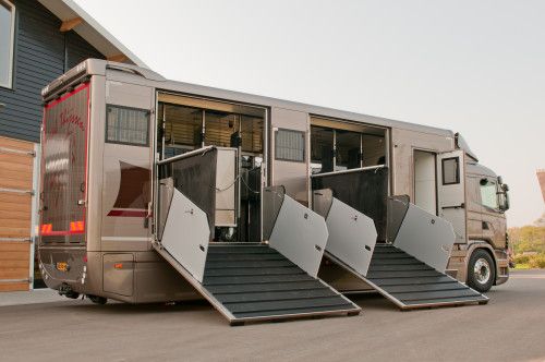 three vehicles are parked in front of a building with their doors open to allow them to load or unload