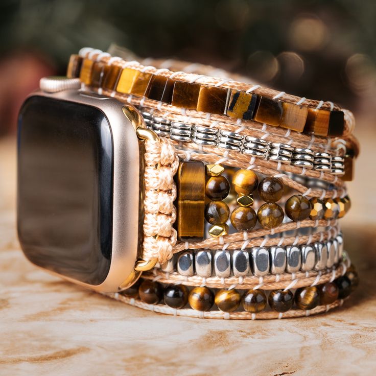 Adding a touch of elegance and nature to your Apple Watch, this Treehut watch strap features semiprecious tiger eye stones, a stone that exudes an air of mystery and romance, and metal accents with stunning golden-brown hues and mesmerizing chatoyancy. The stone's silky smooth texture and intricate patterns create a sense of depth and movement, like a glimpse into a hidden world of magic and enchantment. *Strap only; Apple Watch not included. Please check the back of your Apple Watch to make sur Bohemian Silver Watch Bands With Bracelet Strap, Bohemian Silver Bracelet Strap Watch Bands, Luxury Brown Watch With Bracelet Strap, Luxury Adjustable Metal Apple Watch Band, Luxury Adjustable Stainless Steel Apple Watch Band, Brown Rectangular Jewelry, Bohemian Silver Watch Band As Gift, Bohemian Silver Watch Bands As Gift, Luxury Brown Jewelry With Natural Stones