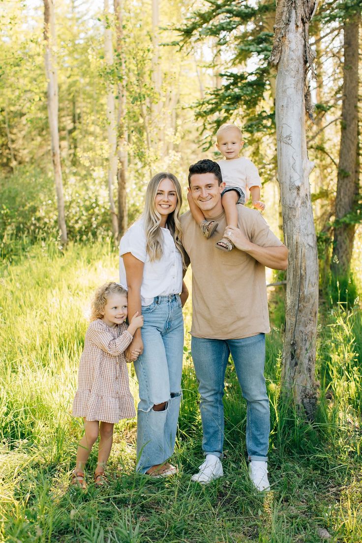 a family posing for a photo in the woods