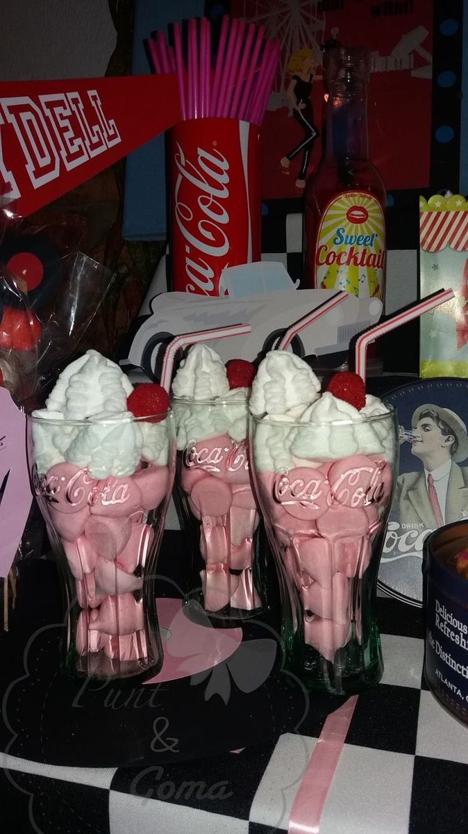 three pink ice cream sundaes sitting on top of a black and white checkered table