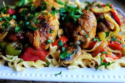 a white plate topped with pasta covered in meat and veggies