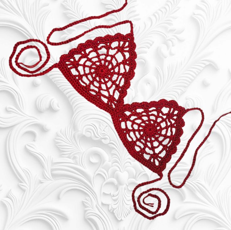 a red lace bralet on a white background with swirls and circles around it