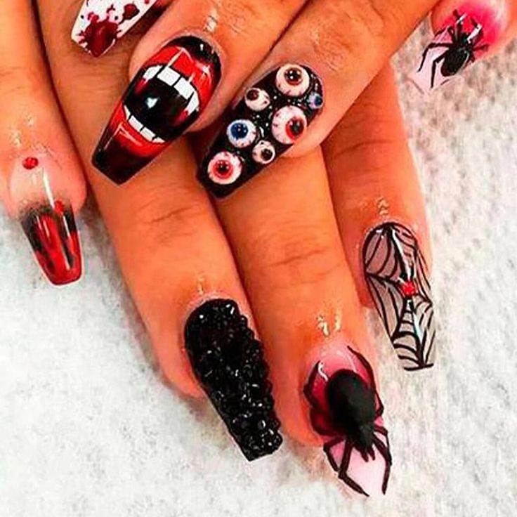 halloween nail art with spider webs and eyeballs on the tips, one is red