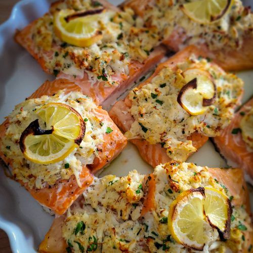 salmon with lemons and herbs on a white plate