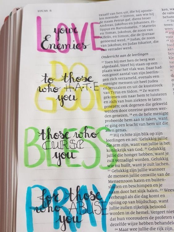 an open bible with colorful writing on it and the words love, god, pray