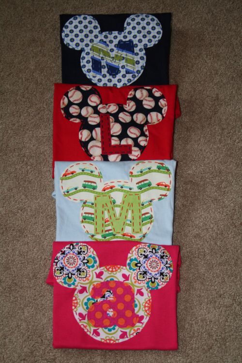 four mickey mouse t - shirts are lined up on the floor, each with different designs