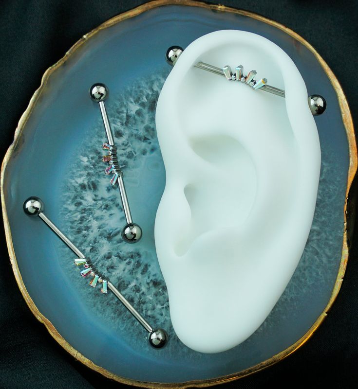 a pair of ear piercings sitting on top of a blue plate