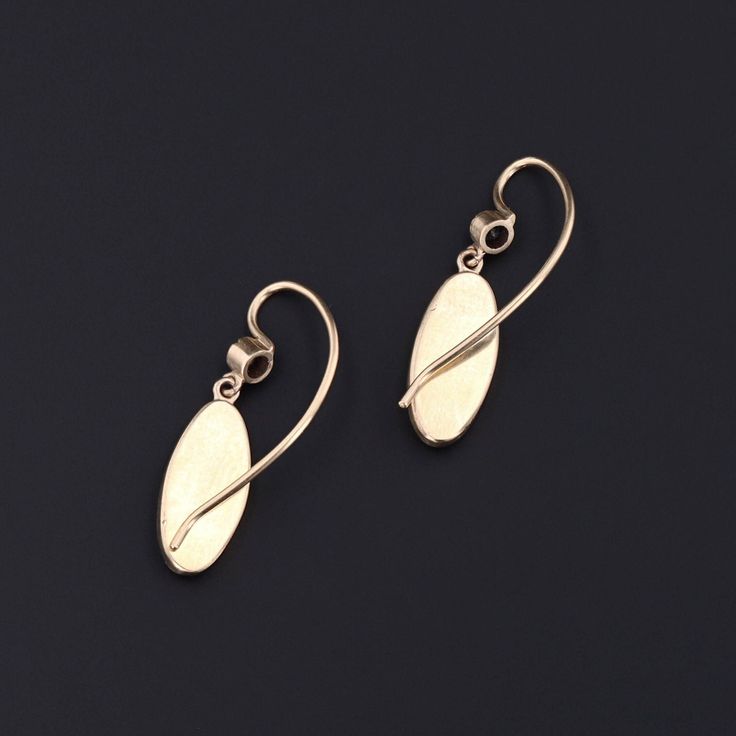 Add a touch of intrigue to any ensemble with these unique insect earrings! To create these earrings, our jeweler carefully cut antique shibayama game pieces (circa 1880) into an oval shape, mounted them in 14k gold, and added 14k ear wires and sapphire surmounts. Each earring measures 1 inch from the top of the ear wire to bottom by 0.3 inches wide, and they are in excellent condition. Materials: Sapphire, Gold. Victorian Oval Pierced Earrings, Antique Oval Earrings, Heirloom 14k Gold Oval Earrings, Heirloom Oval 14k Gold Earrings, Victorian Jewelry With Oval Matching Earrings, Heirloom Oval Gold Earrings, Classic Oval Earrings With Ear Wire, Oval Yellow Gold Brass Earrings, Hallmarked Yellow Gold Oval Cabochon Earrings