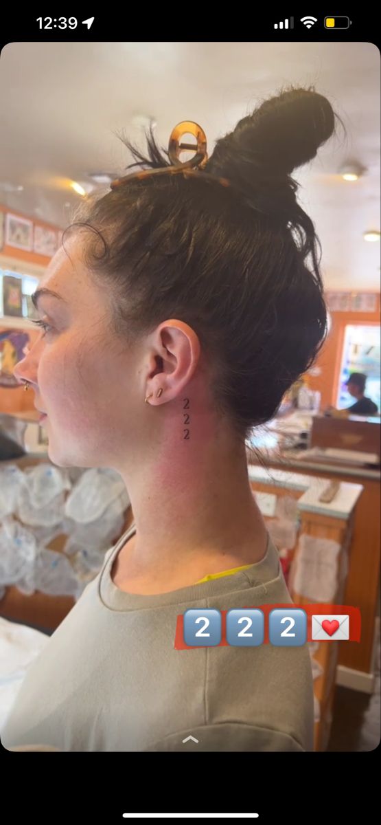 a woman with her hair in a bun and ear piercings is looking at the camera