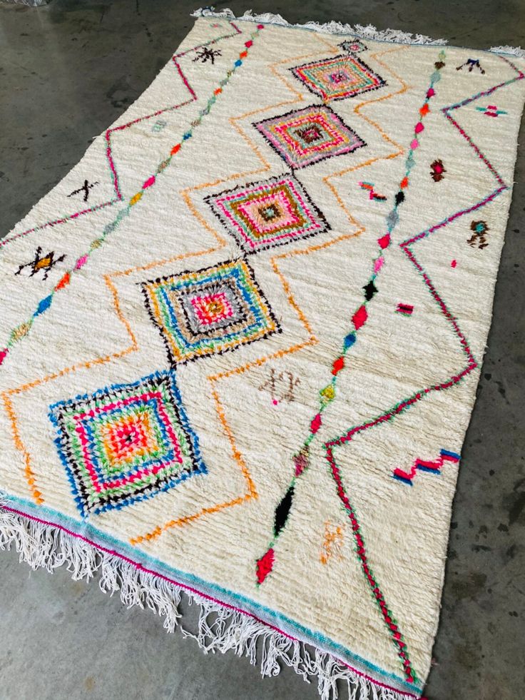 a multicolored rug with fringes on the floor