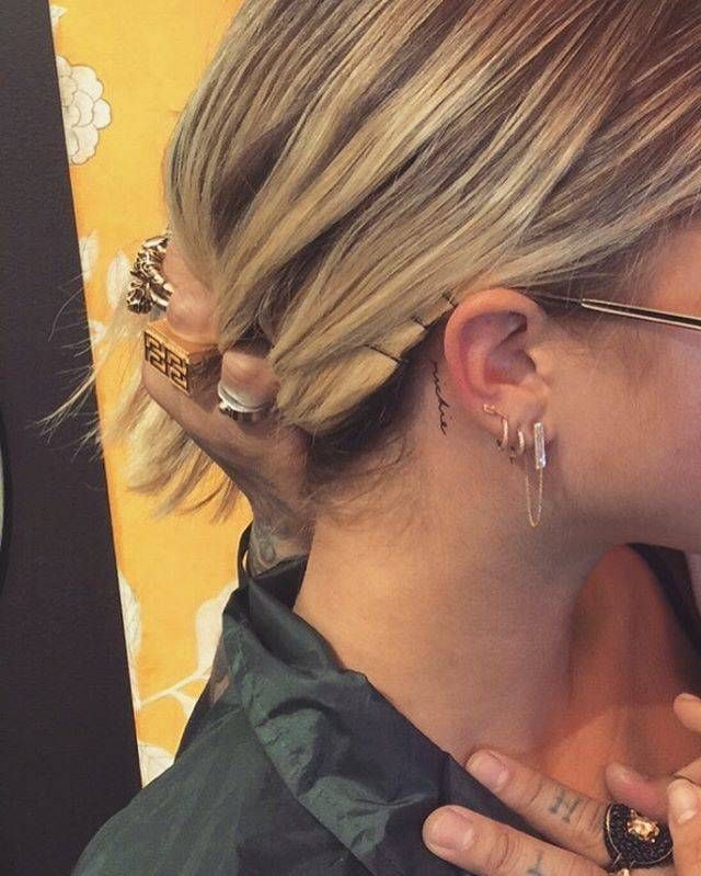 a woman with blonde hair and piercings on her ear