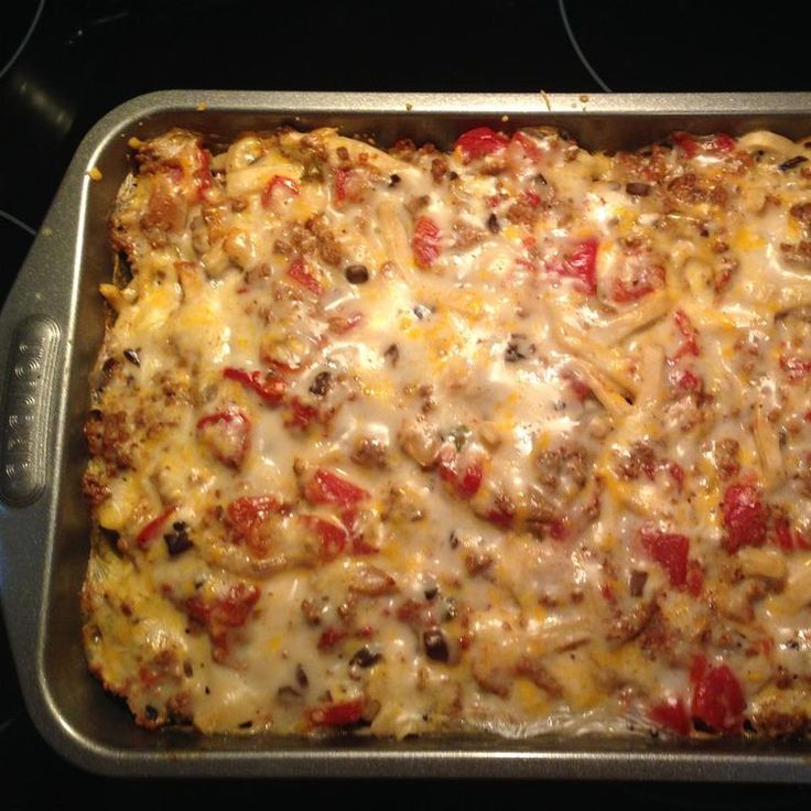 a casserole dish with cheese and meat in it sitting on top of the stove