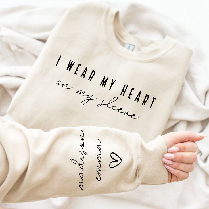 Custom Mama Sweatshirt with Children Name on Sleeve, Crewneck or Hoodie, Custom Neck and Sleeve Design Sweatshirt, Mothers Day, Gift for Mom   🌿WELCOME TO UNIQUE TRENDS DESIGN  If you are looking for soft, comfy, first-rate sweatshirts, you're in the right place! Here at Unique Trends Design, we love what we do and strive to make your shopping experience just right for you. If you have any questions, concerns, or comments about our products, feel free to shoot us a message anytime. Even on weekends and holidays, we'll try our best to respond as quickly as possible! Product Details Unisex Sweatshirts: - Gildan Brand -50% cotton - Light/medium weight and soft, this sweatshirt is sure to be your next favorite sweatshirt. 🌿Sizing and Coloring Please make sure you select the right color and s Heart On My Sleeve, Letter Print Sweatshirt, Mama Shirts, Mama Sweatshirt, Mom Sweatshirt, Heart On, Look Plus, Plus Size Casual, Casual Sweatshirt