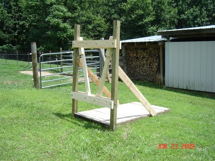 a wooden structure sitting on top of a lush green field